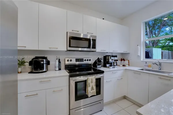 a kitchen with white cabinets and appliances