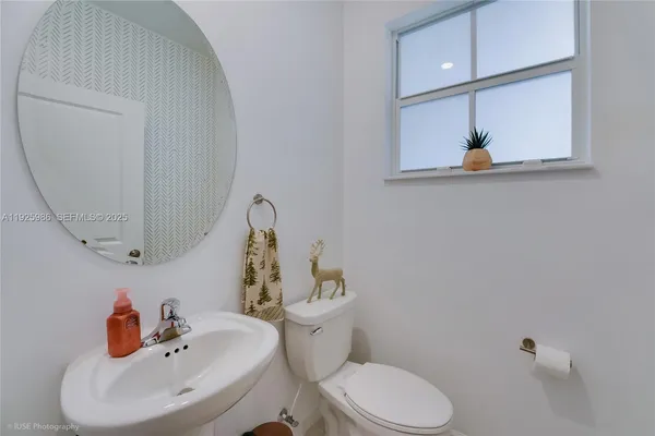 a bathroom with a sink mirror and toilet