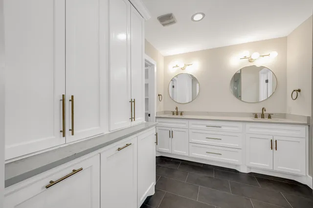 a bathroom with double vanity and a mirror