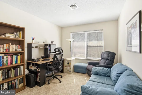 a living room with furniture and a book shelf