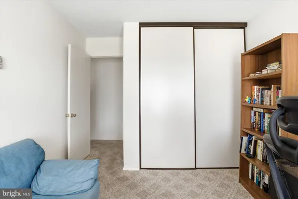 a living room with furniture a bookshelf and a window