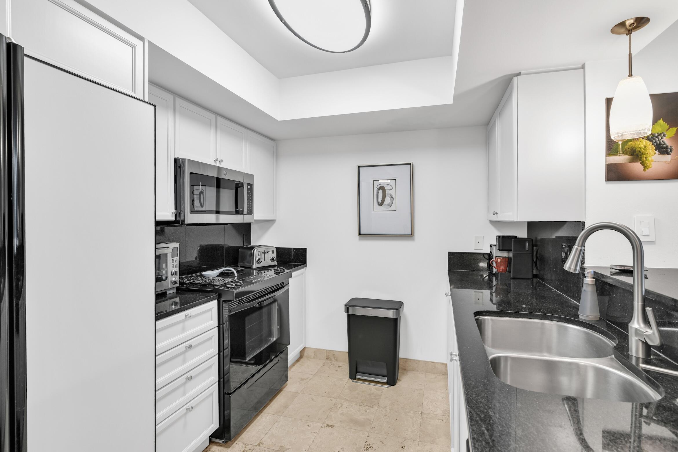 99 Southeast Mizner Boulevard, Unit 848 Boca Raton, FL 33432 - Photo 5 of 22 a kitchen with stainless steel appliances granite countertop a sink and a stove top oven