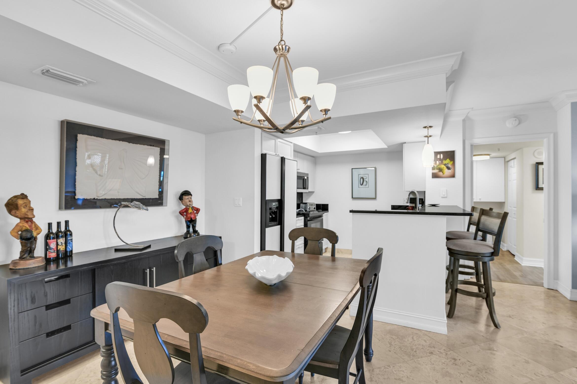 99 Southeast Mizner Boulevard, Unit 848 Boca Raton, FL 33432 - Photo 7 of 22 a view of a dining room with furniture and a chandelier
