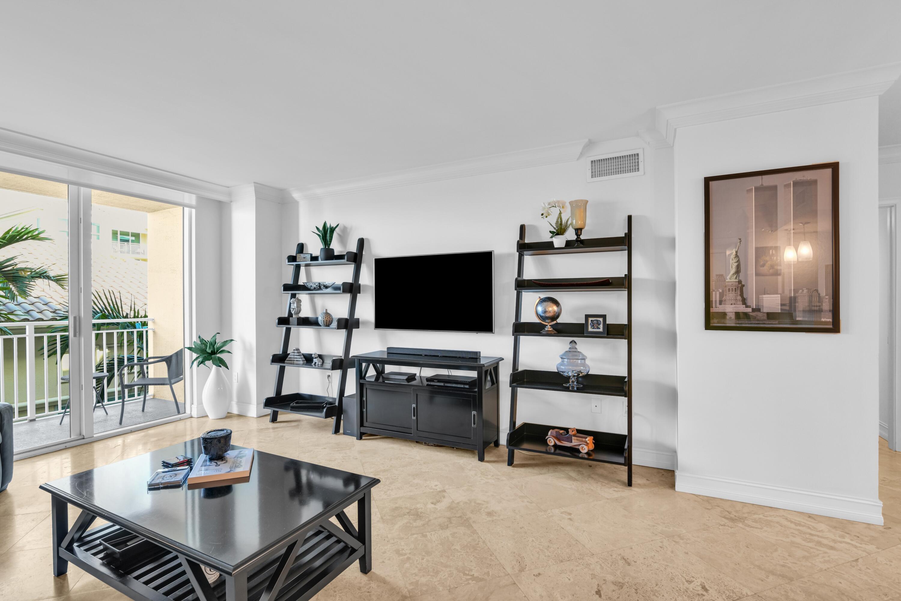 99 Southeast Mizner Boulevard, Unit 848 Boca Raton, FL 33432 - Photo 9 of 22 a living room with furniture and a flat screen tv
