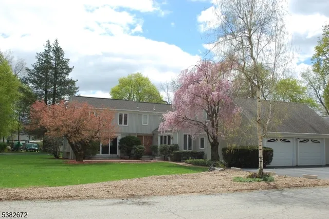 a view of a house next to a yard with big trees
