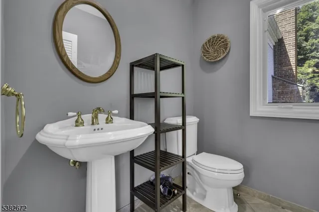 a bathroom with a toilet a sink and a mirror