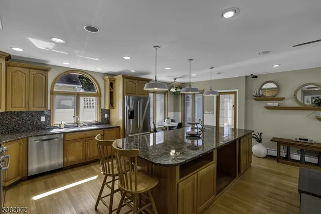 a kitchen with stainless steel appliances granite countertop stove top oven and cabinets