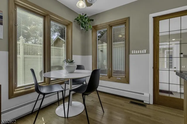 a dining room with furniture window and wooden floor