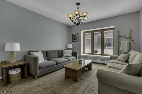a living room with furniture a chandelier and a window