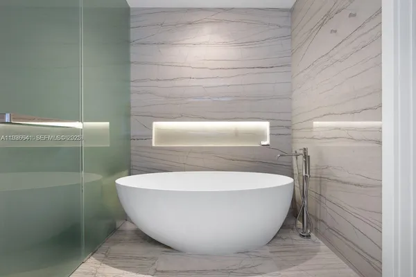 a white tub sitting next to a shower
