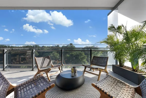 a view of a roof deck with couches and a fire pit