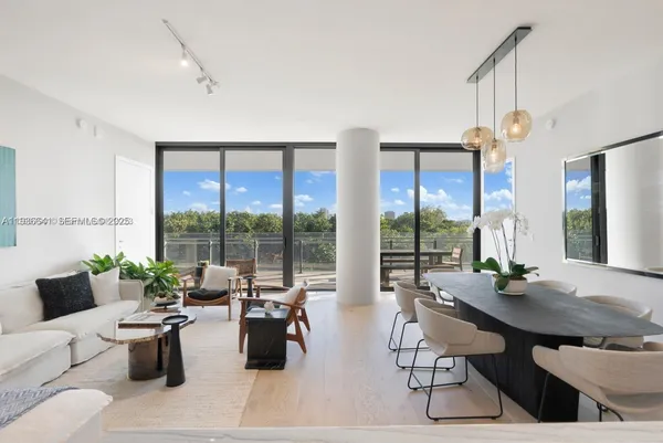 a living room with furniture a large window and a table