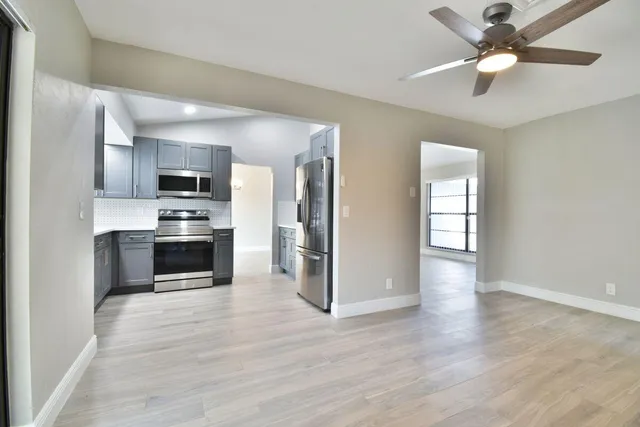 a kitchen with a refrigerator and a stove top oven