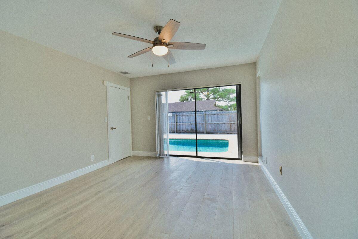 9425 Longmeadow Circle Boynton Beach, FL 33436 - Photo 15 of 34 an empty room with wooden floor fan and windows
