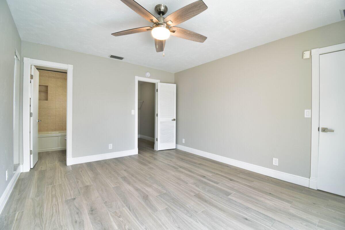 9425 Longmeadow Circle Boynton Beach, FL 33436 - Photo 17 of 34 an empty room with wooden floor and ceiling fan