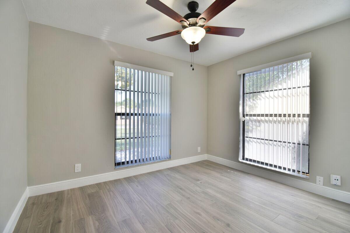 9425 Longmeadow Circle Boynton Beach, FL 33436 - Photo 20 of 34 an empty room with wooden floor fan and windows
