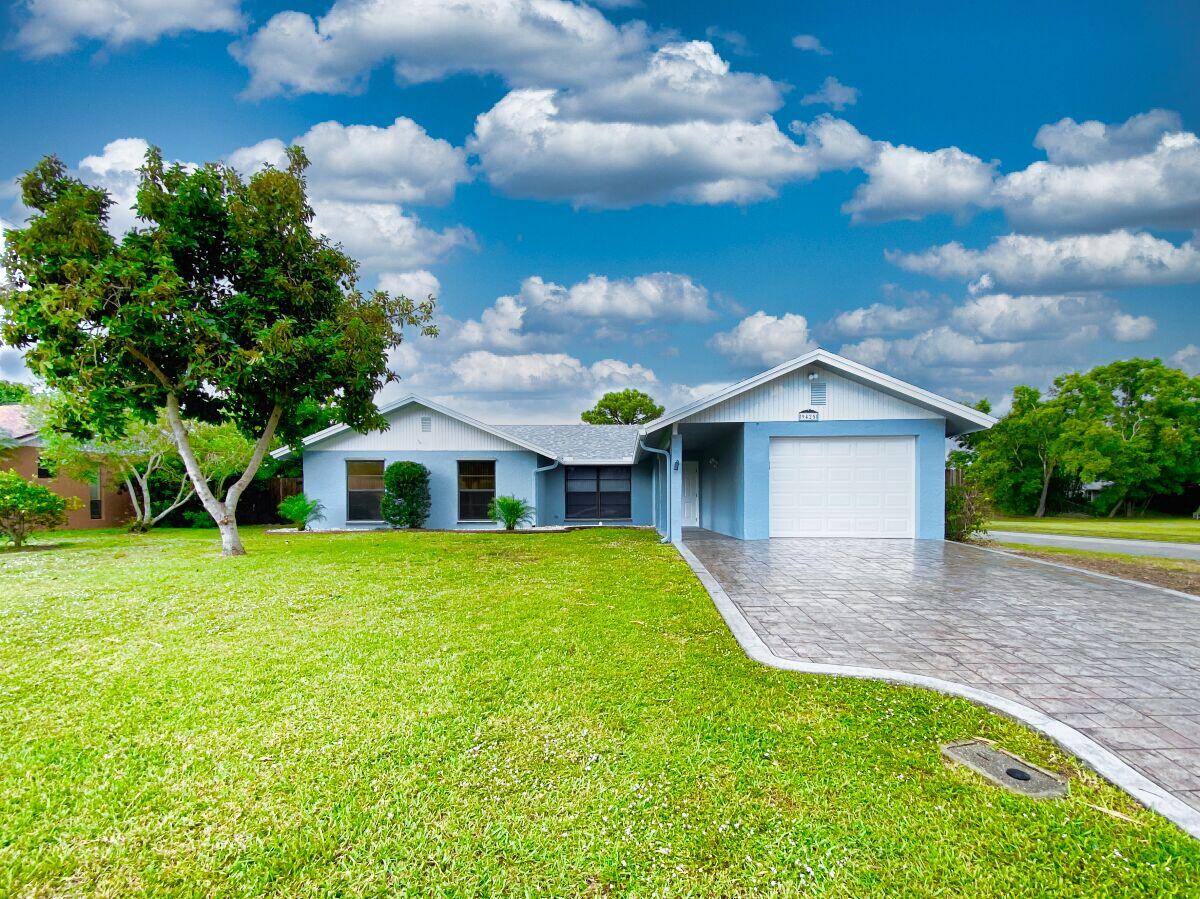9425 Longmeadow Circle Boynton Beach, FL 33436 - Photo 2 of 34 a front view of a house with garden