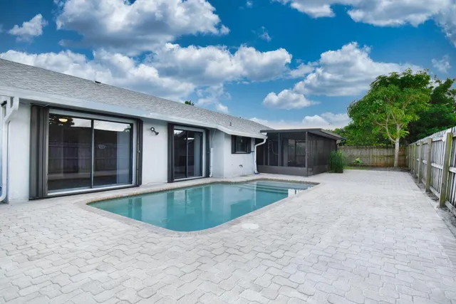 a view of house with swimming pool and outdoor seating