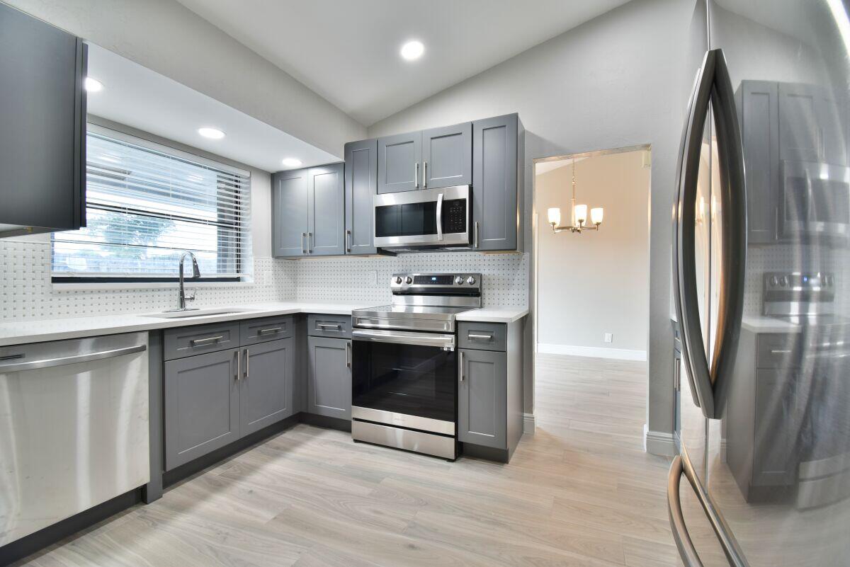 9425 Longmeadow Circle Boynton Beach, FL 33436 - Photo 5 of 34 a kitchen with stainless steel appliances granite countertop a refrigerator a sink a stove a microwave and island