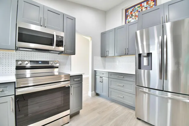 a kitchen with stainless steel appliances white cabinets and a refrigerator