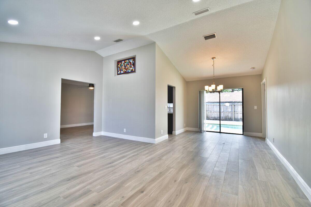 9425 Longmeadow Circle Boynton Beach, FL 33436 - Photo 9 of 34 an empty room with wooden floor and window