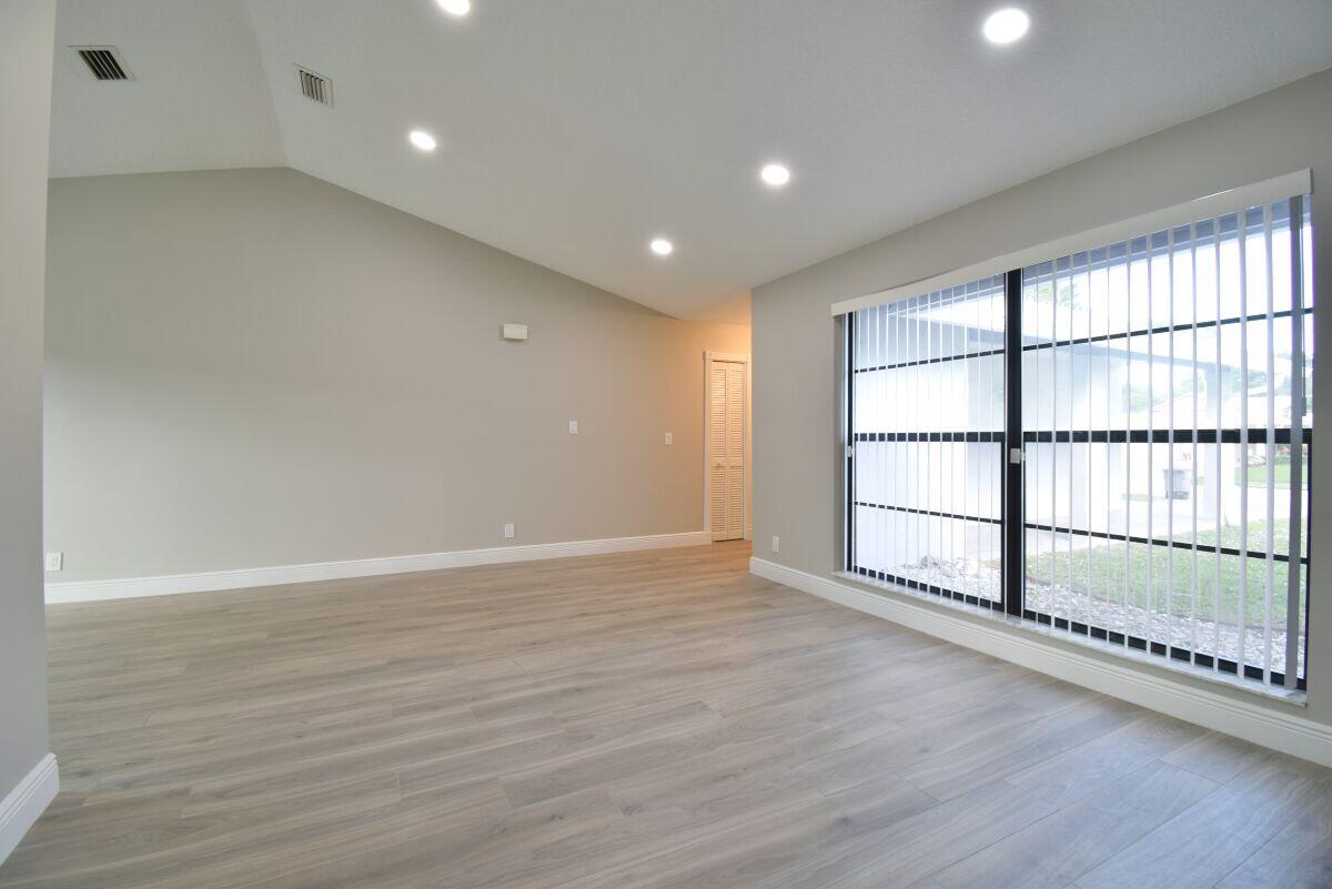 9425 Longmeadow Circle Boynton Beach, FL 33436 - Photo 10 of 34 a view of an empty room with wooden floor and a window