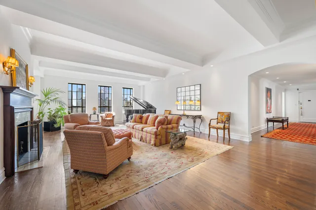 a living room with furniture a wooden floor and a fireplace