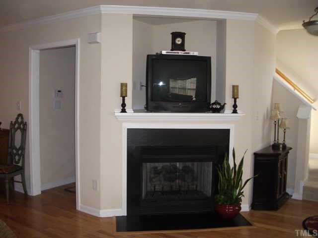 9814 Layla Avenue Raleigh, NC 27617 - Photo 4 of 7 a living room with a fireplace and wooden floor