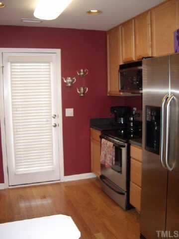 9814 Layla Avenue Raleigh, NC 27617 - Photo 6 of 7 a kitchen with stainless steel appliances granite countertop a refrigerator and a stove top oven
