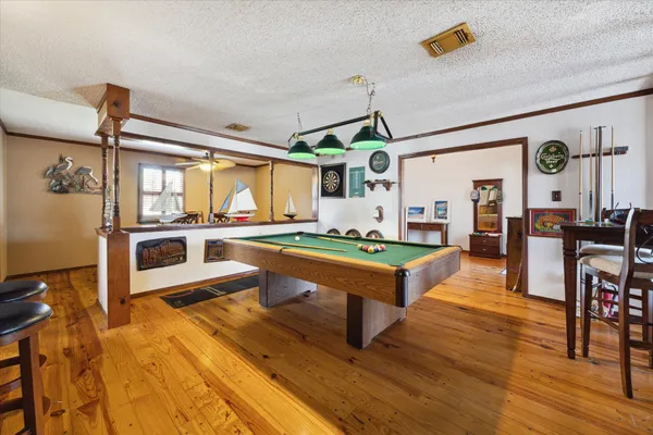 a living room with stainless steel appliances kitchen island granite countertop furniture and a wooden floor