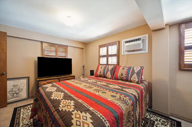 a bedroom with a bed and a flat screen tv