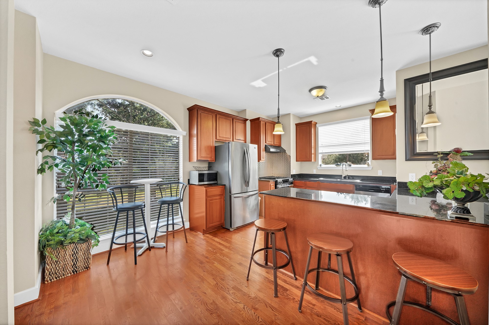 a kitchen with stainless steel appliances a table and chairs in it