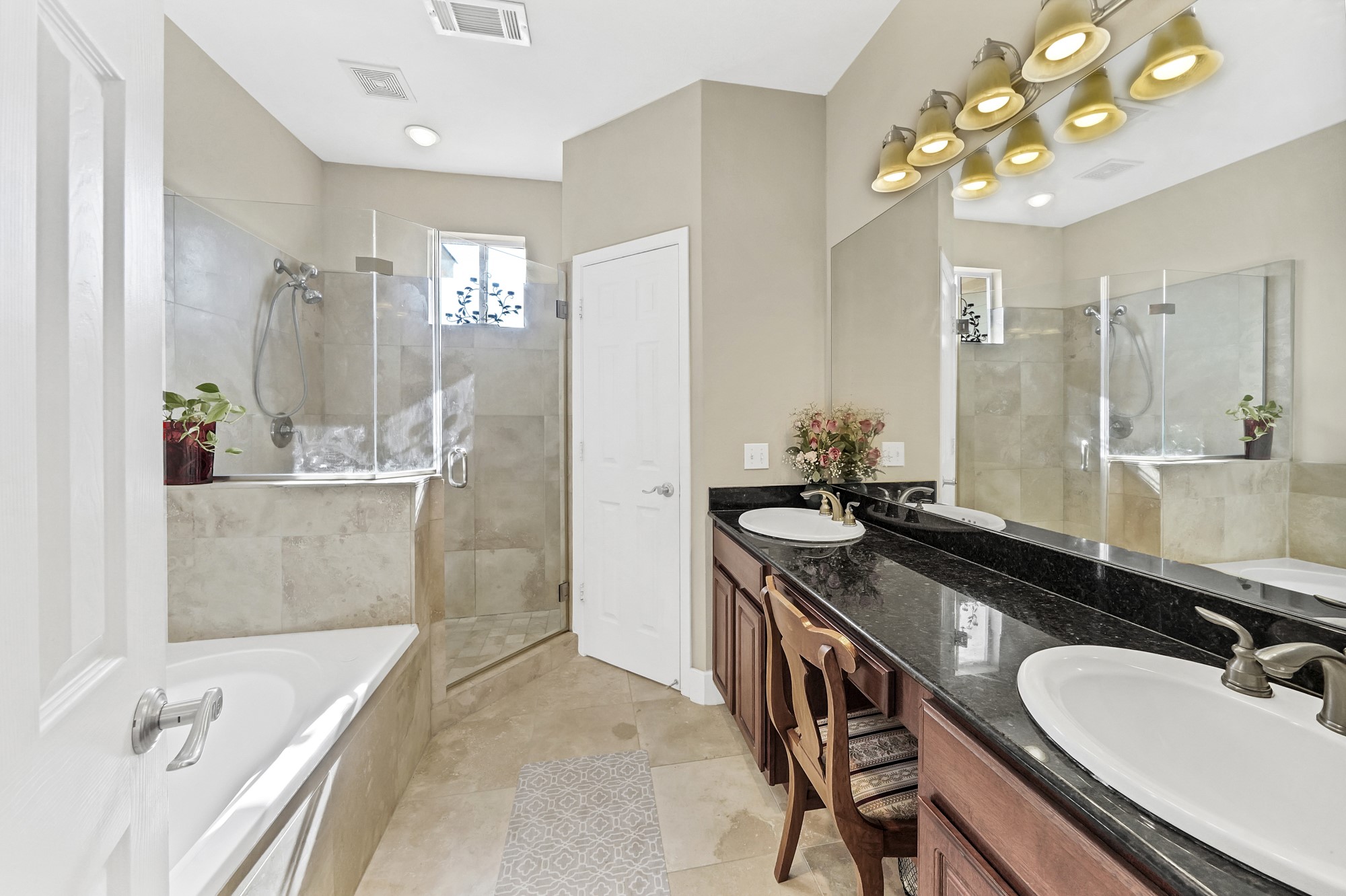 5206 Petty Street Houston, TX 77007 - Photo 16 of 26 a bathroom with a granite countertop double vanity sink a bathtub a mirror and vanity