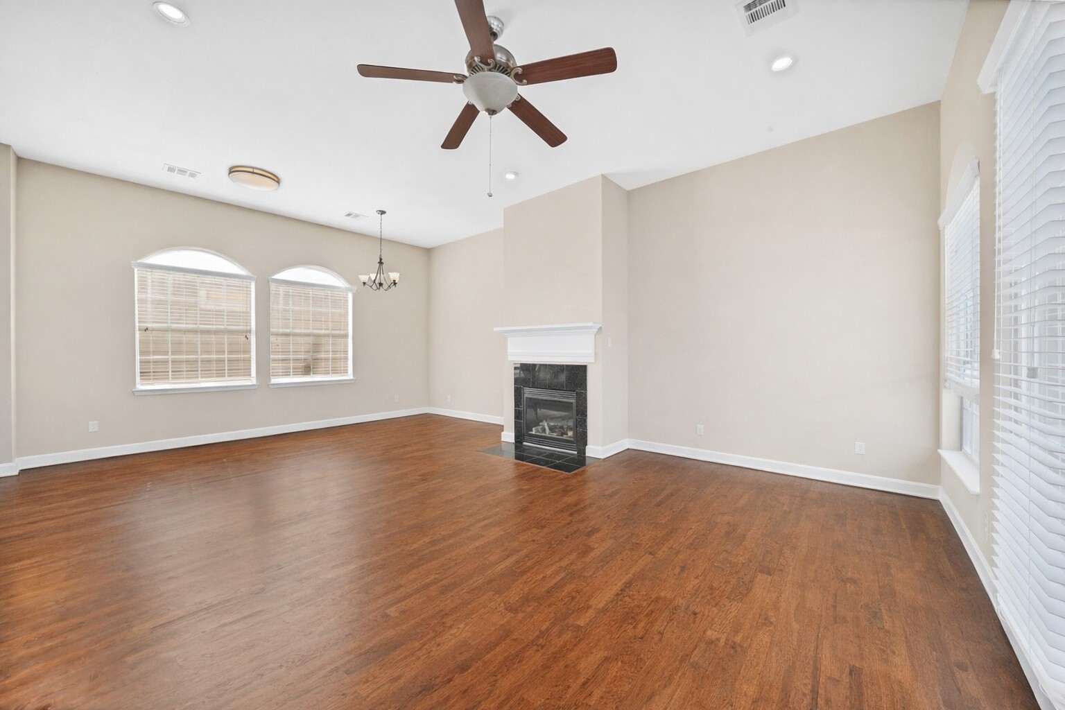 5206 Petty Street Houston, TX 77007 - Photo 10 of 26 an empty room with wooden floor ceiling fan and windows