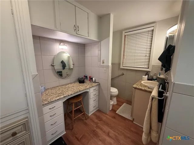 a bathroom with a granite countertop toilet sink and mirror