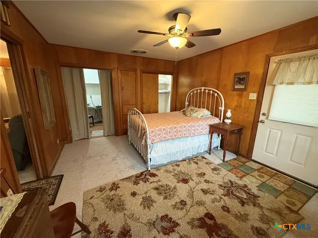 a bedroom with a bed a dresser and flat screen tv