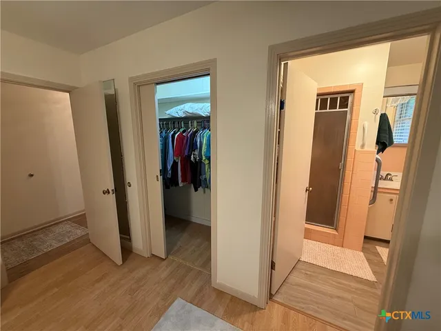 a view of a hallway with wooden floor and closet