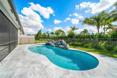 a view of a swimming pool with a yard and plants