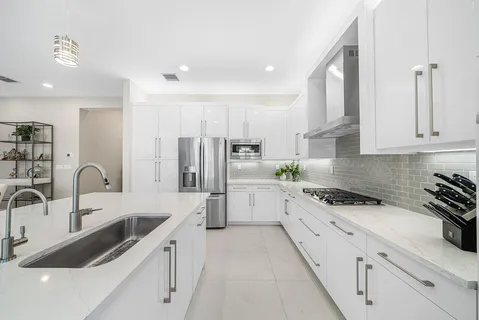 a kitchen with granite countertop a sink stainless steel appliances and cabinets