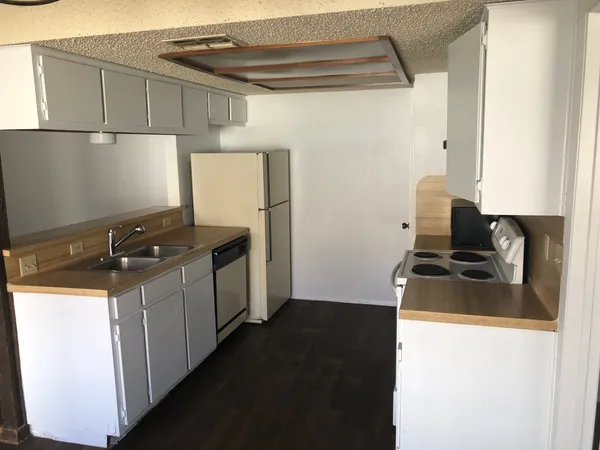 a kitchen with a refrigerator and a stove