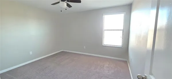 a room with a window and a chandelier fan