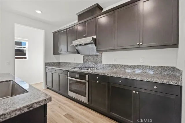 a kitchen with granite countertop a sink and cabinets