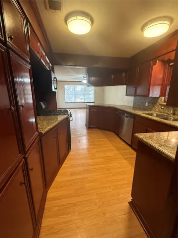 a large kitchen with stainless steel appliances a large counter top