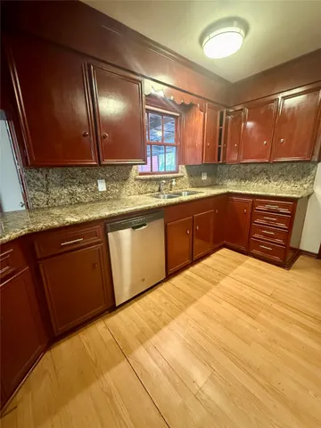 a large kitchen with granite countertop a sink and cabinets