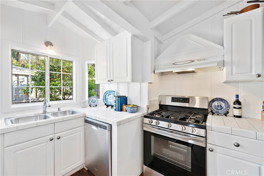31521 Summit Road Laguna Beach, CA 92651 - Photo 8 of 21 Kitchen with wood floors, high pitched beamed ceiling. Stainless range and dishwasher. Window opens to the private, enclosed yard and the smell of the tangerine tree.