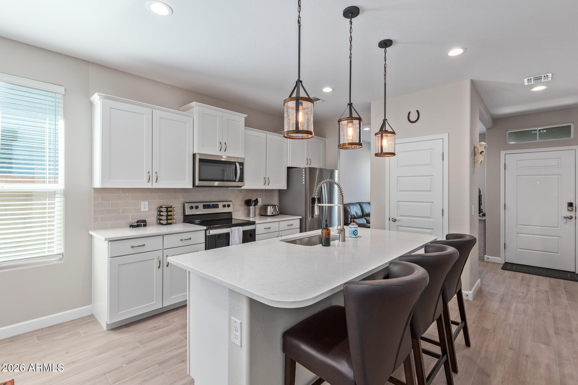 8835 South 166th Avenue Goodyear, AZ 85338 - Photo 19 of 23 a kitchen with a stove a refrigerator a sink a dining table and chairs