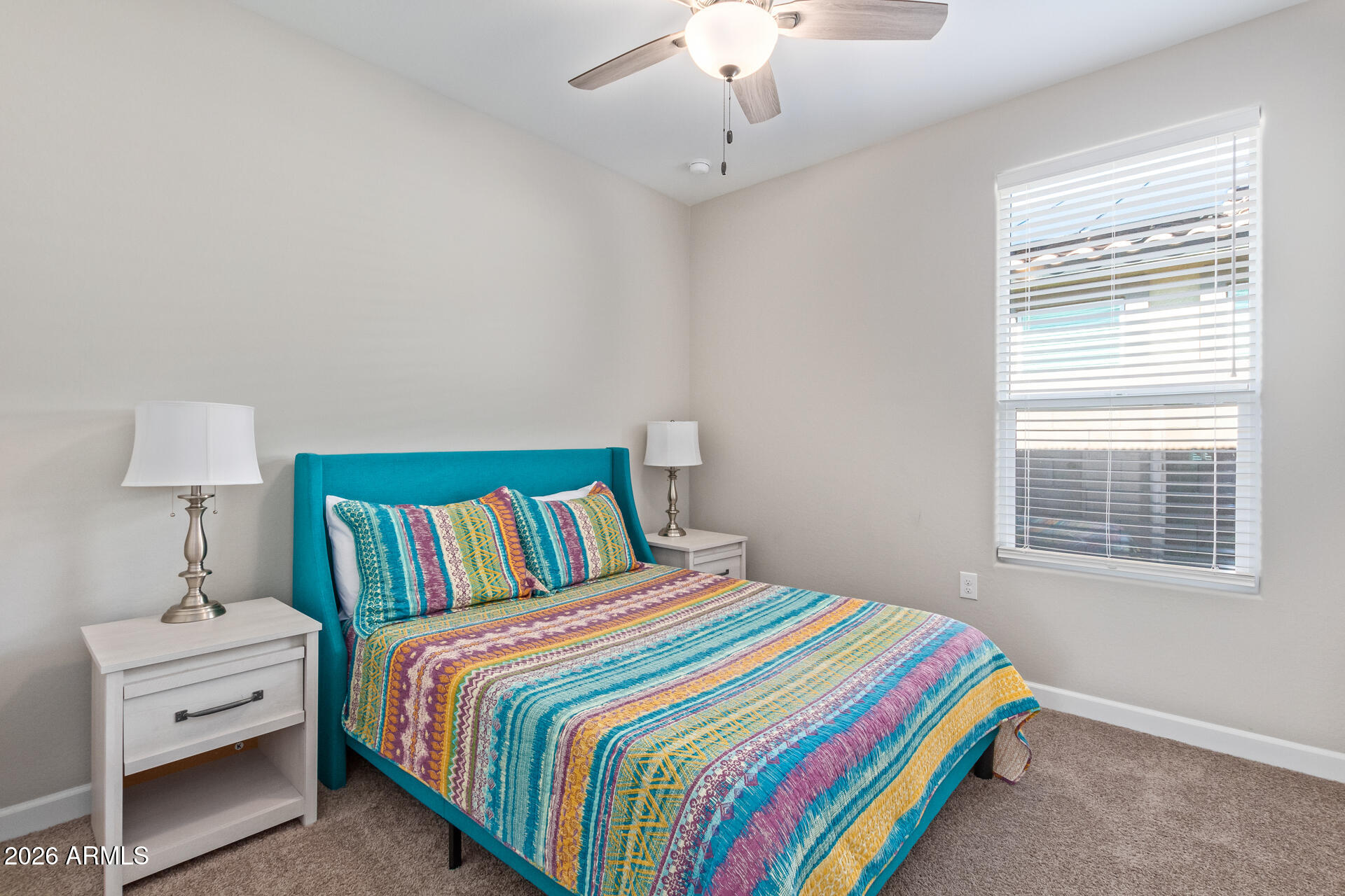 8835 South 166th Avenue Goodyear, AZ 85338 - Photo 6 of 23 a bedroom with a bed and a lamp on dresser
