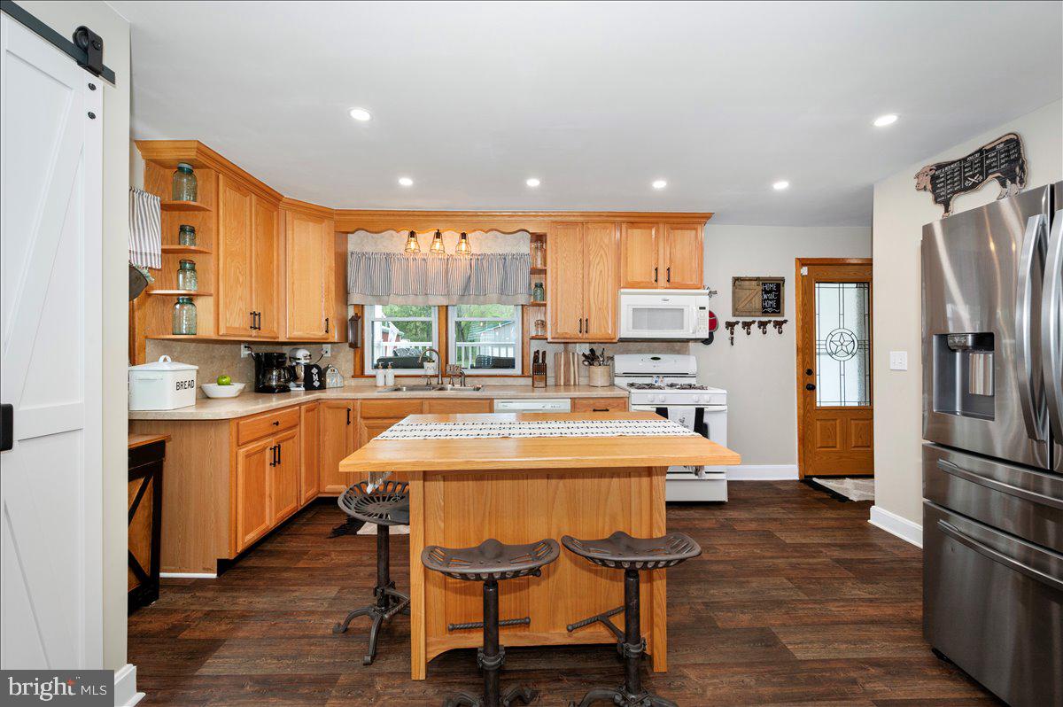 7117 Blue Mountain Road Thurmont, MD 21788 - Photo 17 of 80 a kitchen with stainless steel appliances granite countertop a refrigerator a sink dishwasher a stove and white cabinets with wooden floor