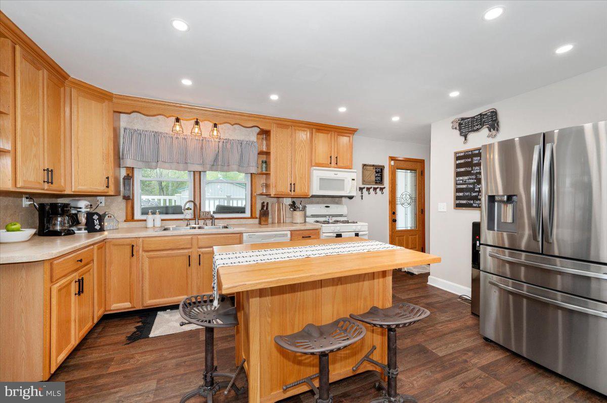 7117 Blue Mountain Road Thurmont, MD 21788 - Photo 18 of 80 a open kitchen with stainless steel appliances granite countertop a refrigerator a stove top oven a sink and white cabinets with wooden floor