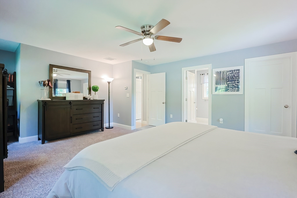 131 Pommogussett Road Rutland, MA 01543 - Photo 27 of 38 a bedroom with a large bed and a chandelier